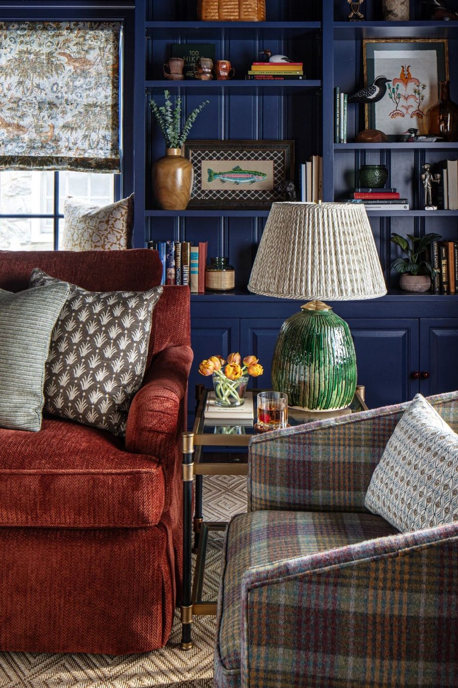 Library with navy shelving and red velvet sofa